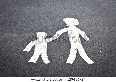 Painted parent and child sign on a tarmac surface