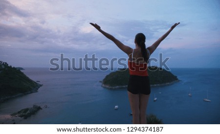 Woman practicing yoga fitness exercise on high place with amazing view of island before sunrise.