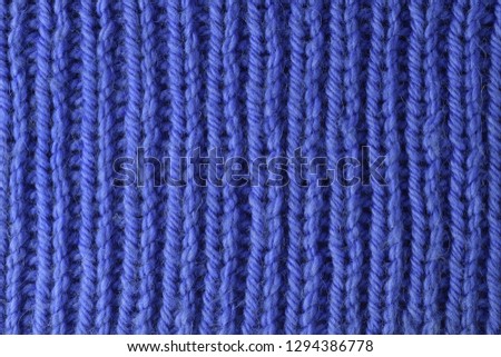Blue wool yarn knitted texture with large stitches. Hand knitted ribbing stitch pattern