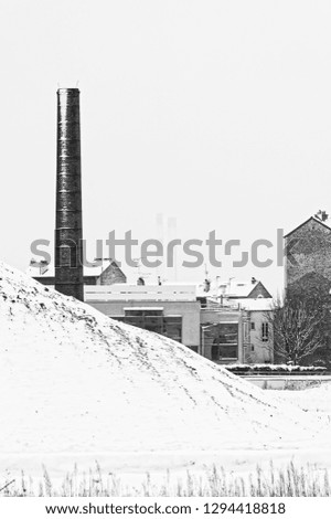 wasteland and industrial chimney under snow in Paris suburb