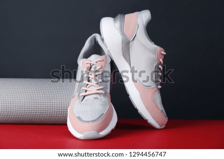 Composition of modern woman training shoes and mat on table