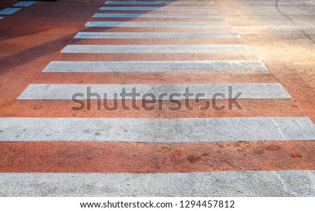 Red​ Crosswalk on the road, Pedestrian crossing with red and white stripes without people close up, crosswalk on the road for safety when people walking cross the street.