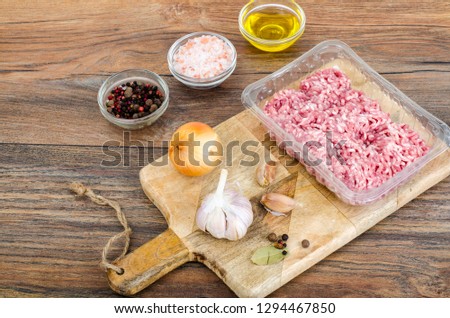 Raw minced meat with spices for cooking on wooden board. Studio Photo