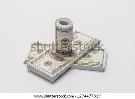 A bunch of American dollars  of 100 dollars notes rolled up and held together with a simple rubber band with two stack of american dollars of 100 dollars isolated on a white background