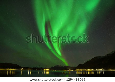 Universal photo with Aurora borealis dancing on a mountains.
Beautiful northern lights above the mountains and the harbor and the coast.
Winter time is a dream for all landscape photographers. 