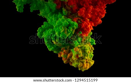 Color splashes of ink isolated on black background. Abstract paint in water