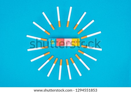 Flat lay with cigarettes and colorful letter blocks isolated on blue, stop smoking concept