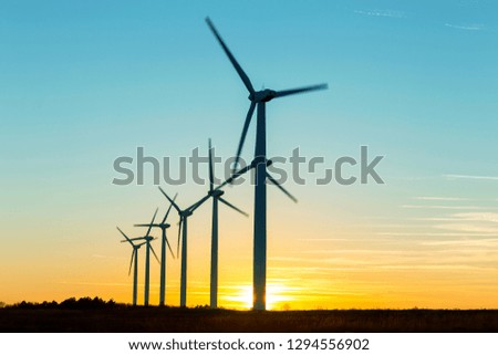 Wind Turbines at Dusk. Landscape sunset with windmills. Renewal source of electricity. Wind turbines field new technology for clean energy on mountain, sunset view with colorful twilight on sky