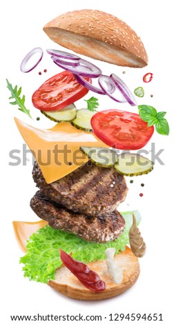 Hamburger ingredients falling down one by one to create a perfect meal. Colorful conceptual picture of burger cooking. Clipping path.