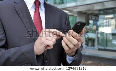 Close Up of Walking Businessman Browsing on Smartphone