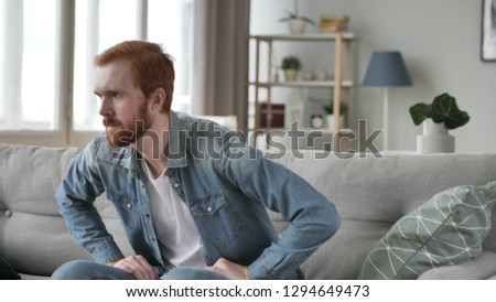 Man Leaving Room, Sitting on Sofa Royalty-Free Stock Photo #1294649473