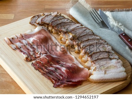 Delicious meat baked in oven with garlic and spices on the wooden desk with purple onion. This picture have made by middle format camera.  