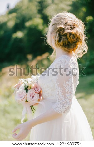 Bride holding an elegant wedding bouquet with roses, peonies and other flowers