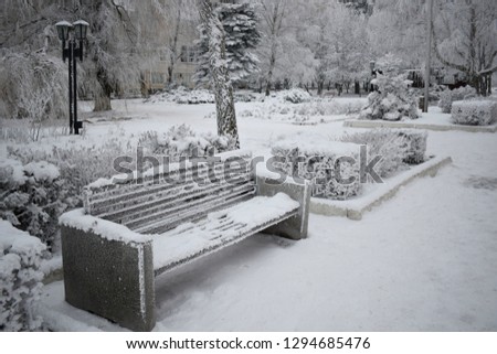 Bench among the snow-covered Park. Winter time.