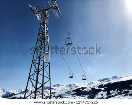 A photo taken from below a Ski Lift in the Alps in Switzerland, with a clear sky