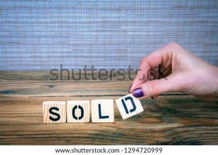 Sold. Wooden letters on the office desk, informative and communication background