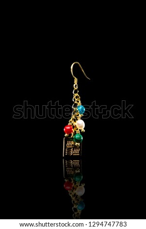 Earrings with beads and pendant on black background