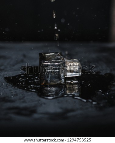 Perfume  that is under water drops on black background