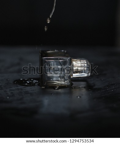Perfume  that is under water drops over black background