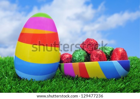 an easter egg of different colors, full of chocolates, on the grass