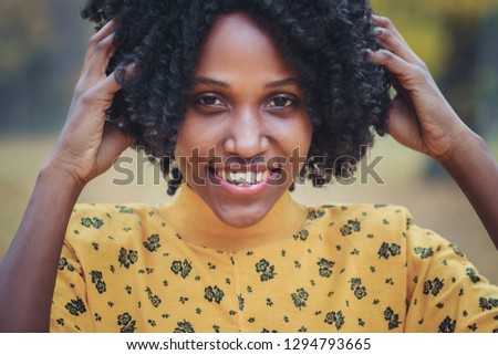 Portrait: Young dark-skinned woman dressed in casual clothes, autumn