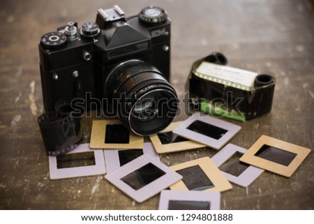  Camera, film and slides on a wooden background
