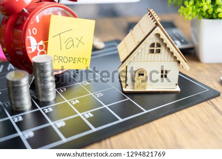 Property Tax Concept-House shape on stacked coins - Image