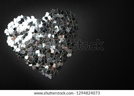Silver heart on a black background. Place for text.