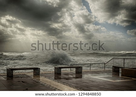 Winter storm on the Mediterranean coast. Strong waves flood the recreation area.
