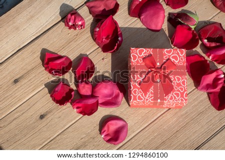 Lovely Gift box with Rose Petals on wooden background for Valentines day