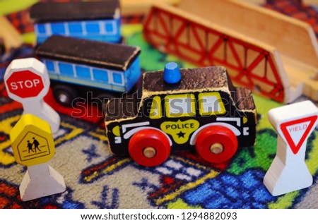 Children's wooden toys, including police car, train cars, and various signs.  
