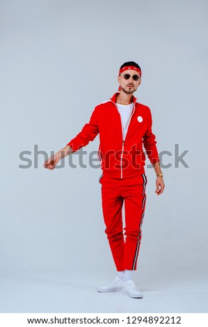 health, fun, people sport concept - happy young man wearing red sport suit on white background. Royalty-Free Stock Photo #1294892212