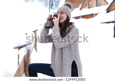 Beautiful girl with old school camera  in the mountains. Winter season.