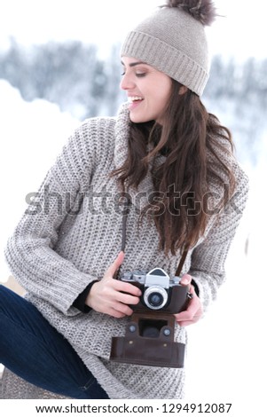 Beautiful girl with old school camera  in the mountains. Winter season.