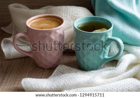 Two Cups of hot coffee or cappuccino and hot tea with lemon. Warm scarf a on wooden table. Good morning. Winter mood concept. Warm autumn or winter picture. Time for relax. Coffee vs Tea. Love. Latte.