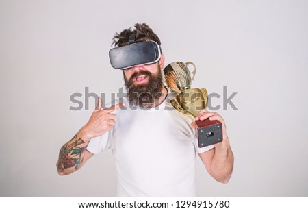 Achievement unlocked. Feel victory in virtual reality games. Achieve victory. Man bearded hipster vr headset holds golden goblet. Man winner virtual competition. Hipster virtual gamer got achievement.