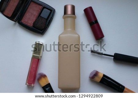 Bottle surrounded with different cosmetics. 