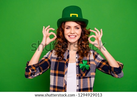 Close up photo of cool attractive she her lady showing up two hands fingers in okey signal glad wearing casual checkered plaid shirt leprechaun headwear isolated on bright green background