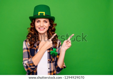 Close up photo of she her lady curly brunette finger shows to empty space feedback wearing casual checkered plaid shirt leprechaun headwear isolated on green vivid vibrant background