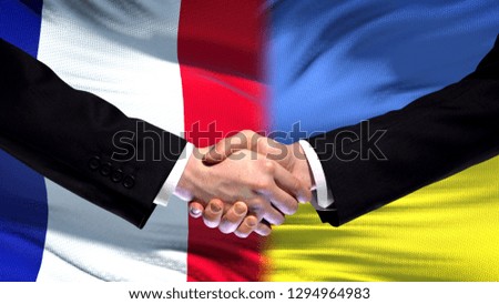 France and Ukraine handshake, international friendship relations flag background