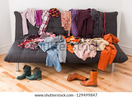 What to wear? Messy colorful clothing on a sofa. Royalty-Free Stock Photo #129499847