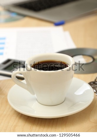 Cup of coffee on office desktop close-up