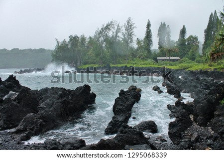 Waves crashing against a rocky coastline on a stormy day Maui Hawaii
