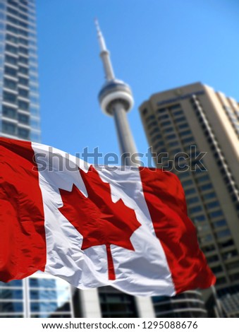  TORONTO, CANADA - Canadian flag is waving front of Toronto CN Tower