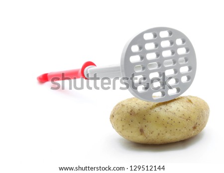 potato masher with raw potato isolated on white background Royalty-Free Stock Photo #129512144