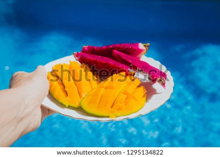 
Served fruit plate near swimming pool. Exotic summer diet. Tropical beach lifestyle.
