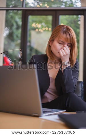 A portrait of working woman being stressful from her job. This picture can be used in concept like business woman having problem, financial, tired people, stressful office, headache, need some rest. 