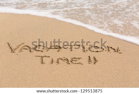 Vacation Time words written into sand on beach by sea in Caribbean Royalty-Free Stock Photo #129513875