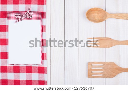 Recipe book, kitchen equipment on white wood background