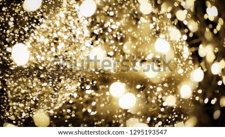 Beautiful Golden light bokeh effect glowing shiny with dark abstract background.